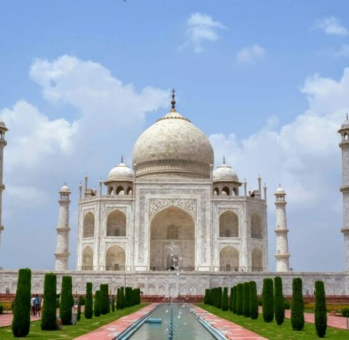 Taj Mahal white marble mausoleum under blue sky in Agra, India
