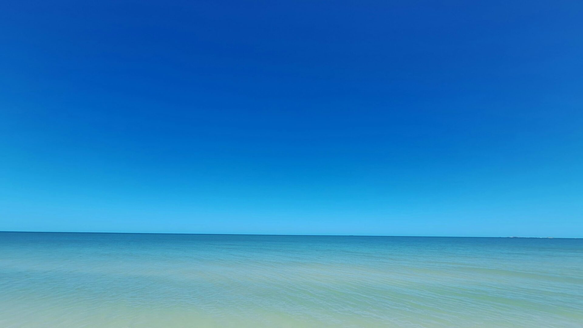 Calm shallow waters and blue sky at Chelem beach on the Gulf of Mexico, Yucatán