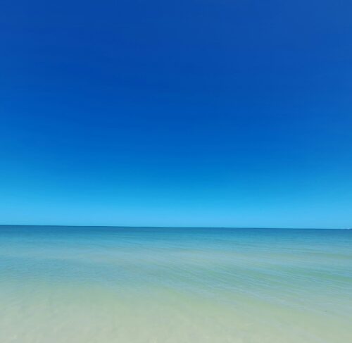 Calm shallow waters and blue sky at Chelem beach on the Gulf of Mexico, Yucatán