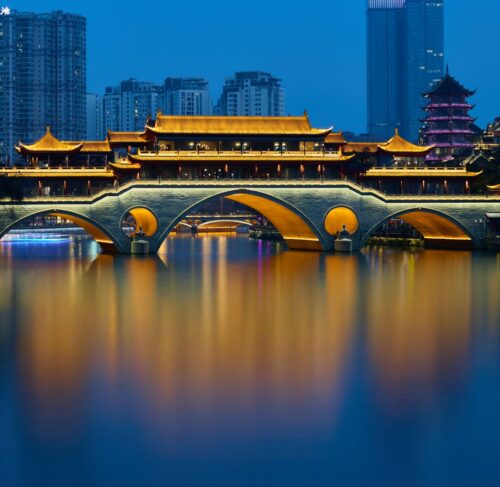 Anshun Bridge over Jinjiang River with Chengdu skyline in background at dusk