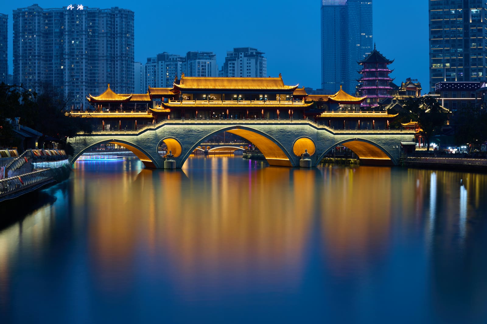 Anshun Bridge over Jinjiang River with Chengdu skyline in background at dusk