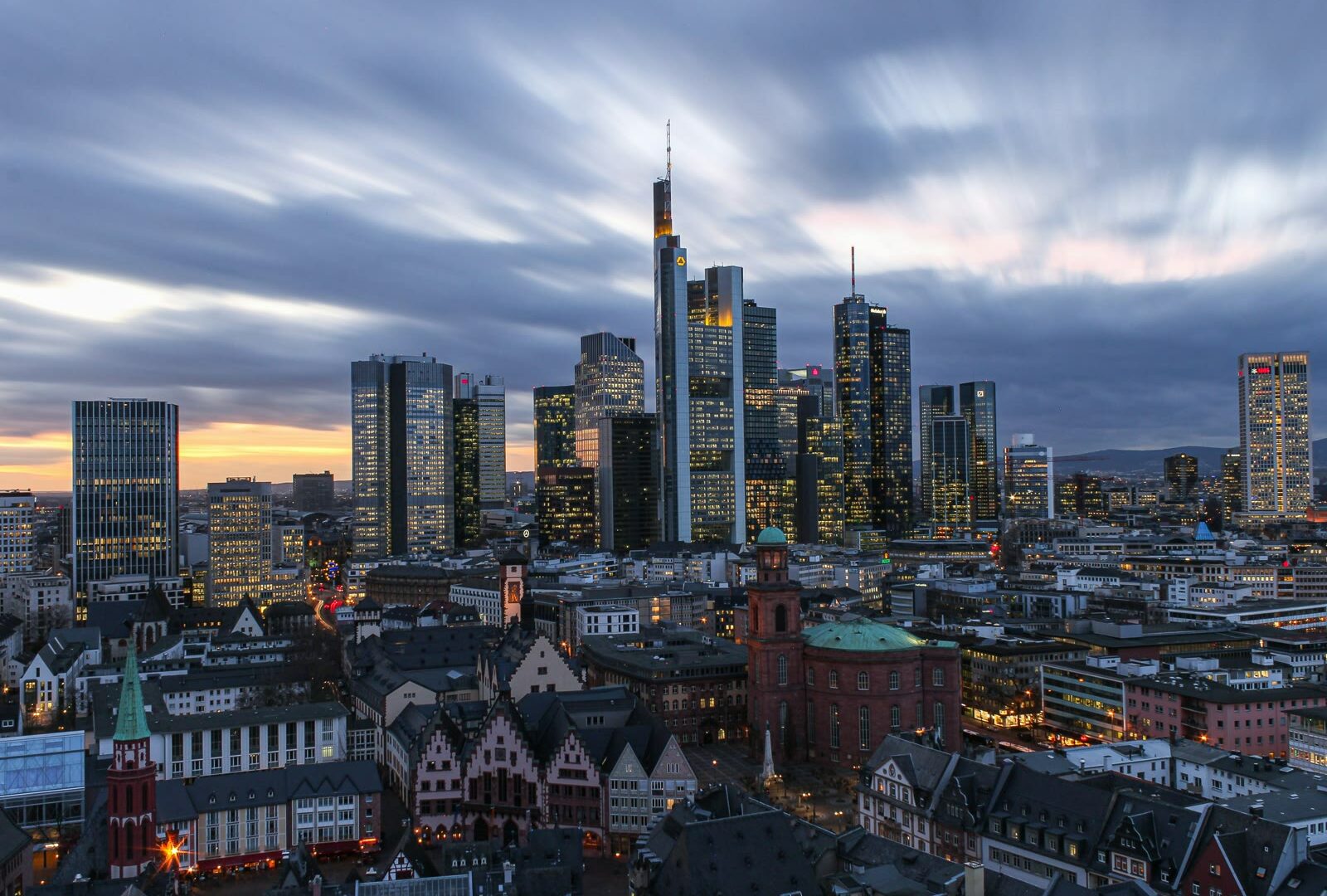 Frankfurt skyline with modern skyscrapers under white clouds during daytime