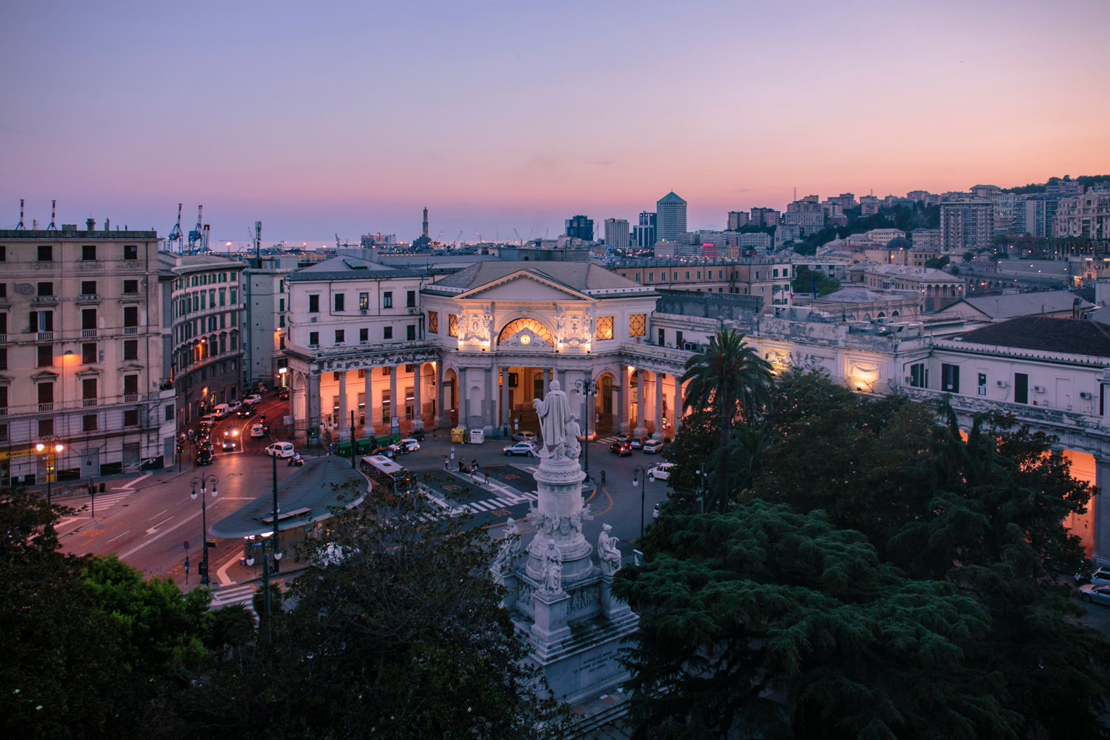 Panoramic sunset view over Genoa Italy old town with colorful buildings, port and Mediterranean Sea in the distance