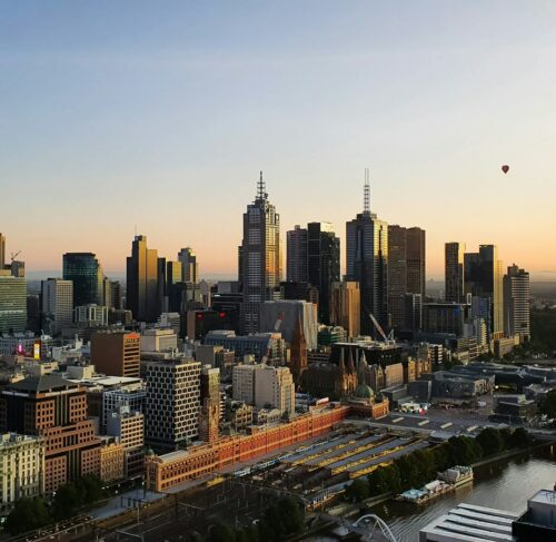 Daytime panoramic view of Melbourne's city skyline with modern skyscrapers and the Yarra River visible