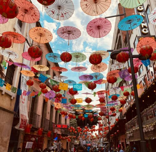 Red and white paper lanterns hanging above a street in Mexico City historic center