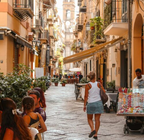 Woman walking on a narrow street in Palermo Sicily old town with historic buildings