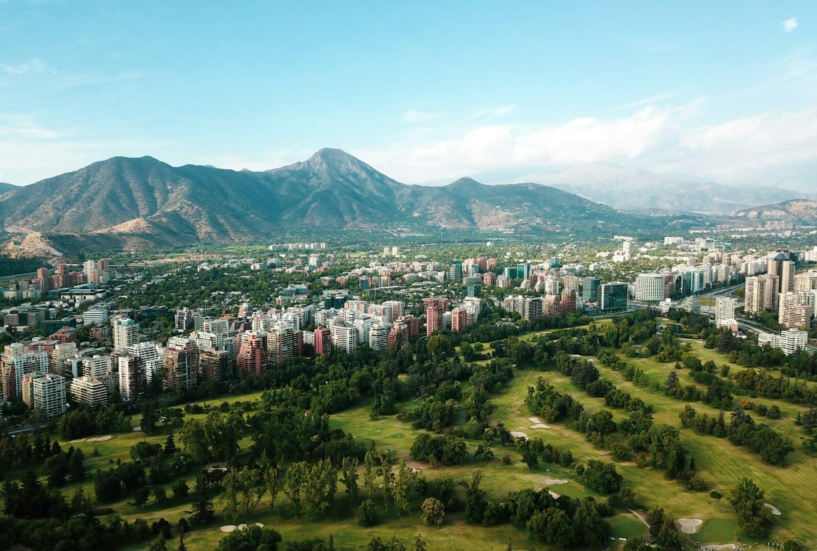 Santiago de Chile city skyline with buildings and green hills under blue sky