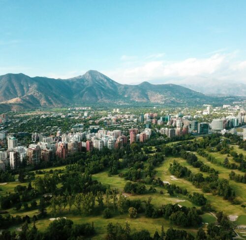 Santiago de Chile city skyline with buildings and green hills under blue sky