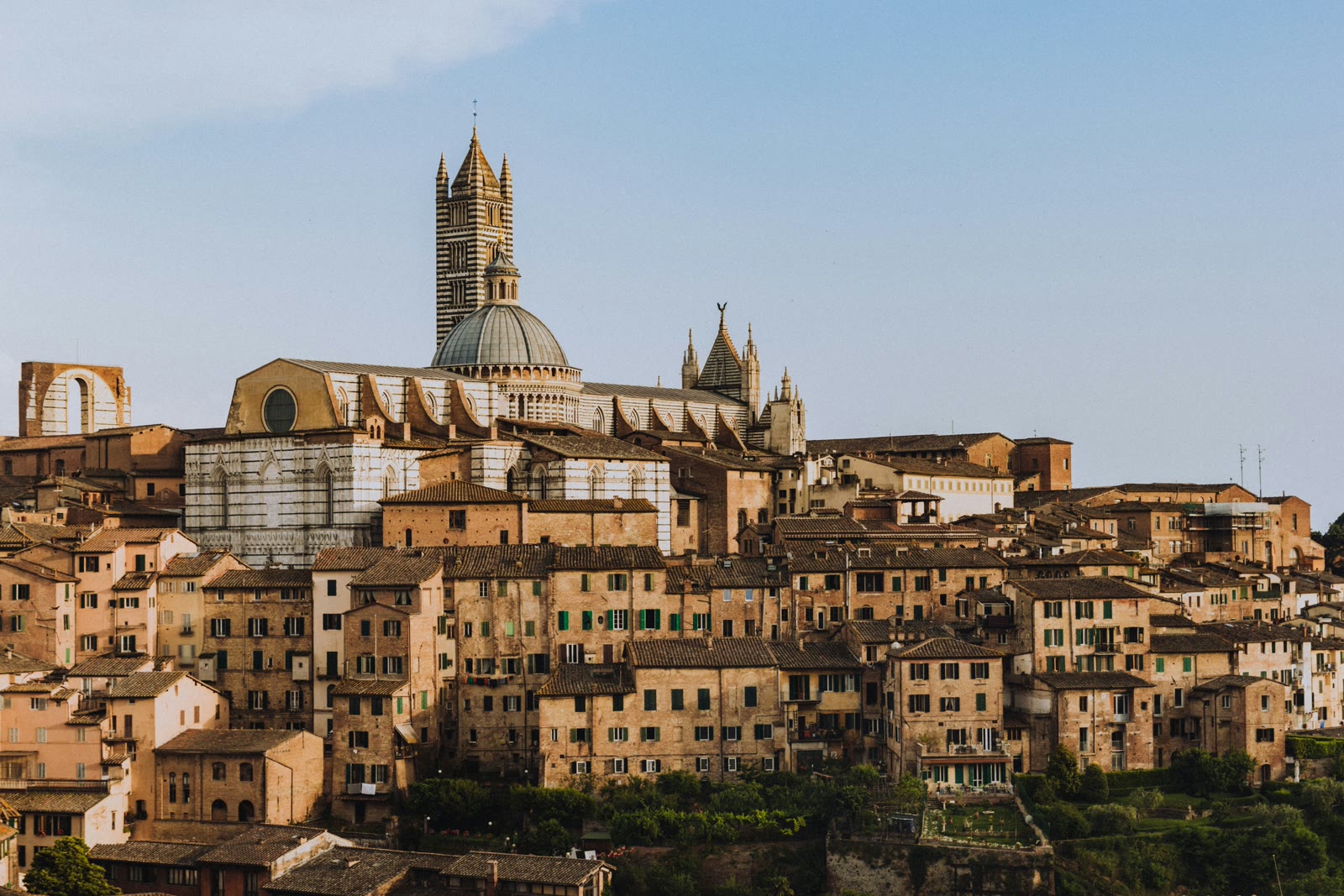 View of Piazza del Campo in Siena with Torre del Mangia and Palazzo Pubblico on a bright day