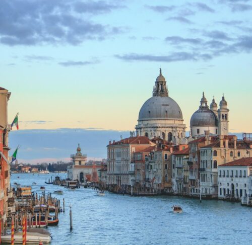 Aerial view of Venice canals and historic buildings under blue sky, Italy