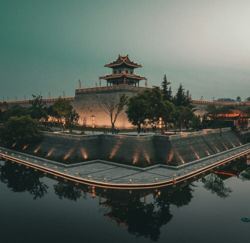 Giant Wild Goose Pagoda in Xi'an China, ancient Buddhist temple with water reflection and modern skyline behind