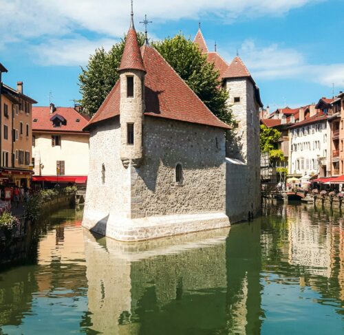 Canal and historic buildings in Annecy with Alps backdrop, Auvergne-Rhone-Alpes, France