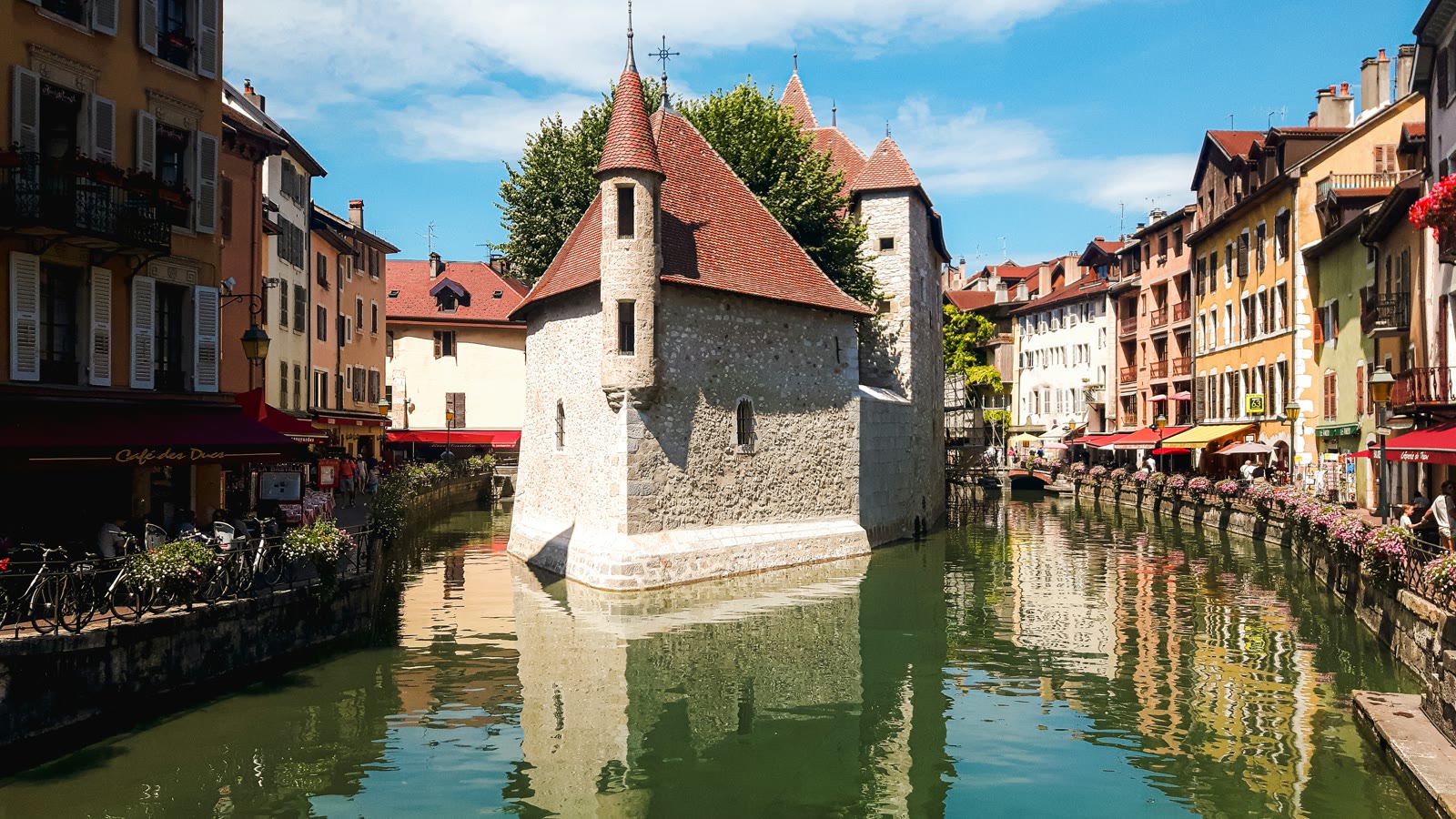 Canal and historic buildings in Annecy with Alps backdrop, Auvergne-Rhone-Alpes, France