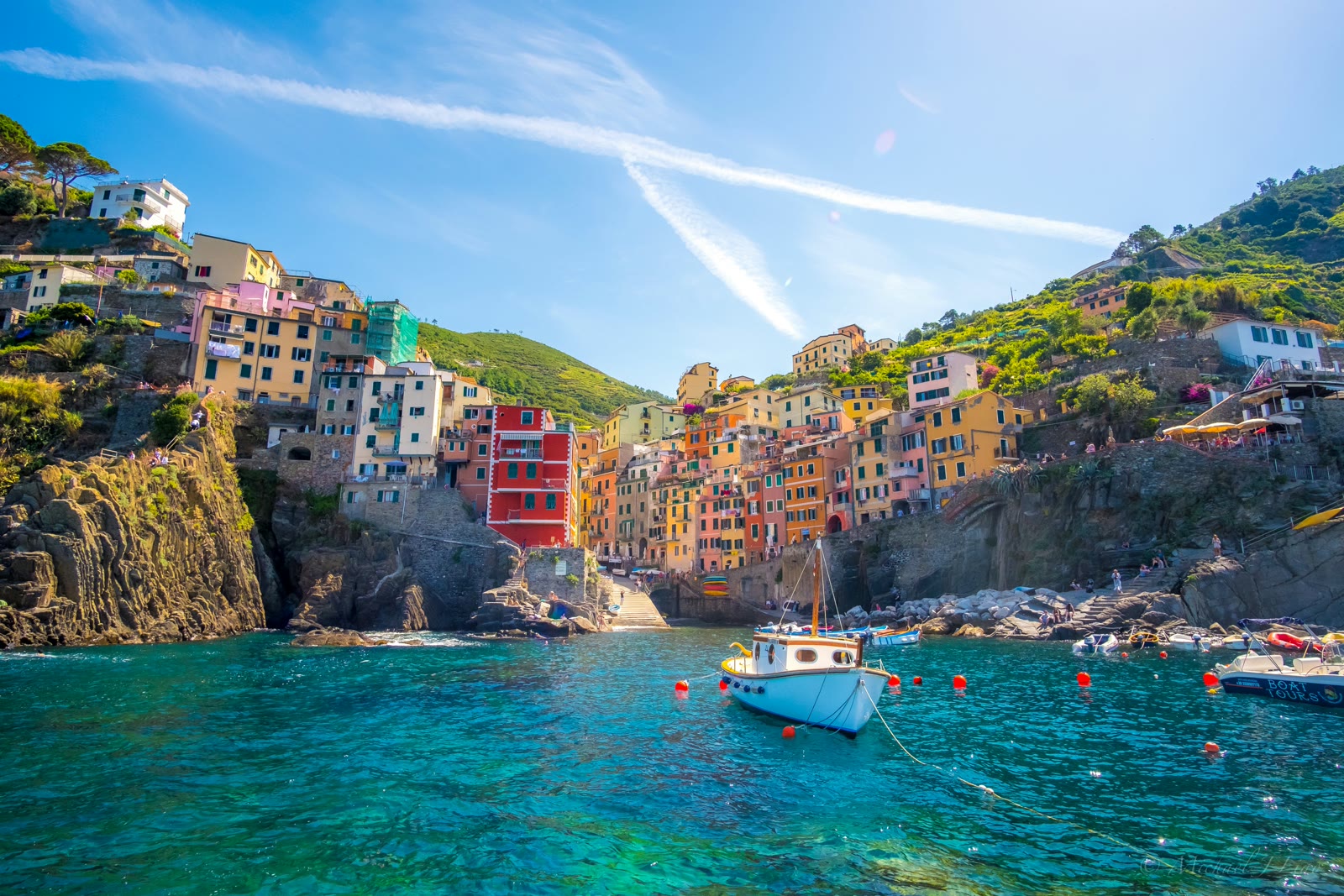 Blue fishing boat near colorful hillside houses in Cinque Terre, Liguria, Italy