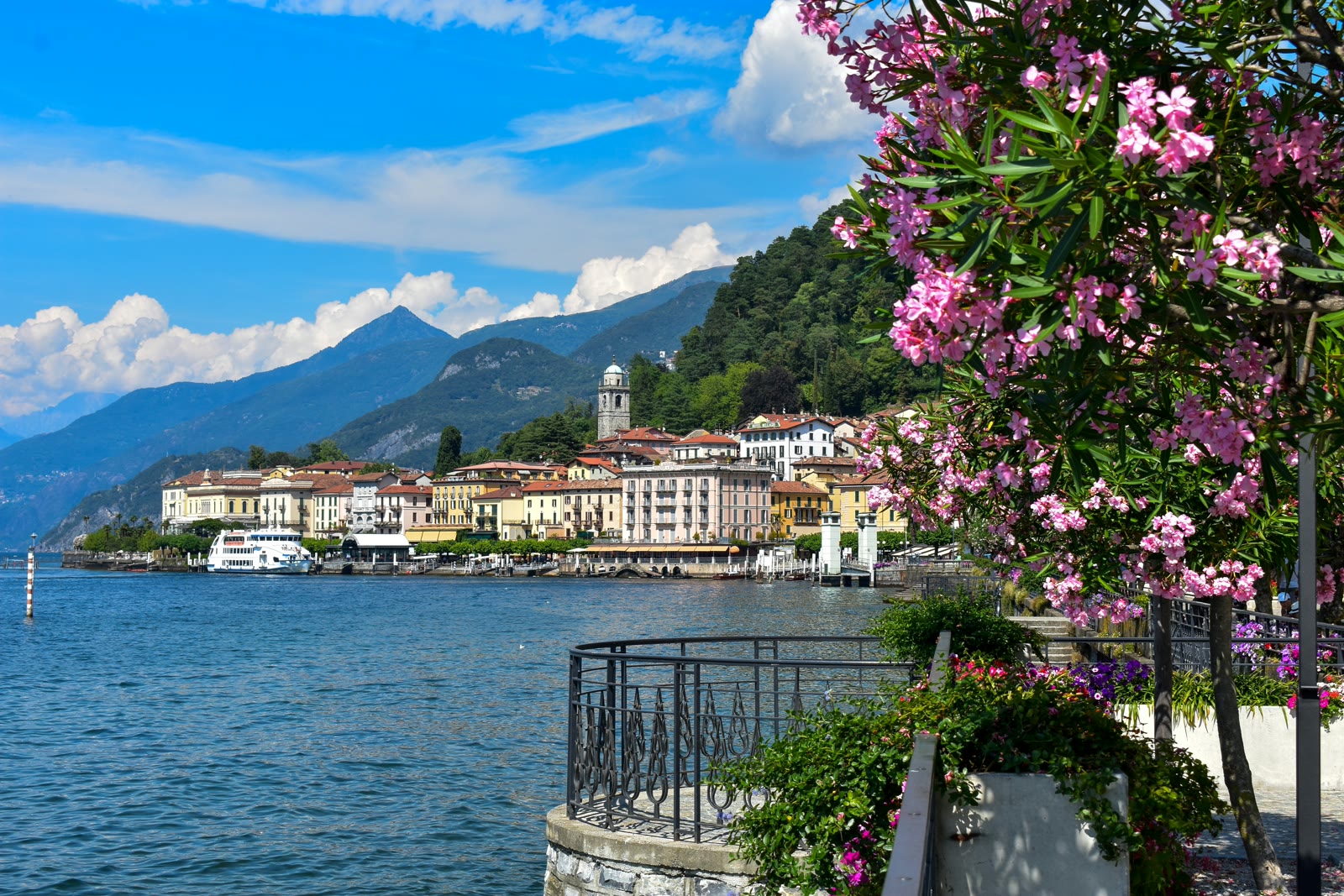 White and brown buildings near Lake Como waterfront under blue sky, Lombardy, Italy