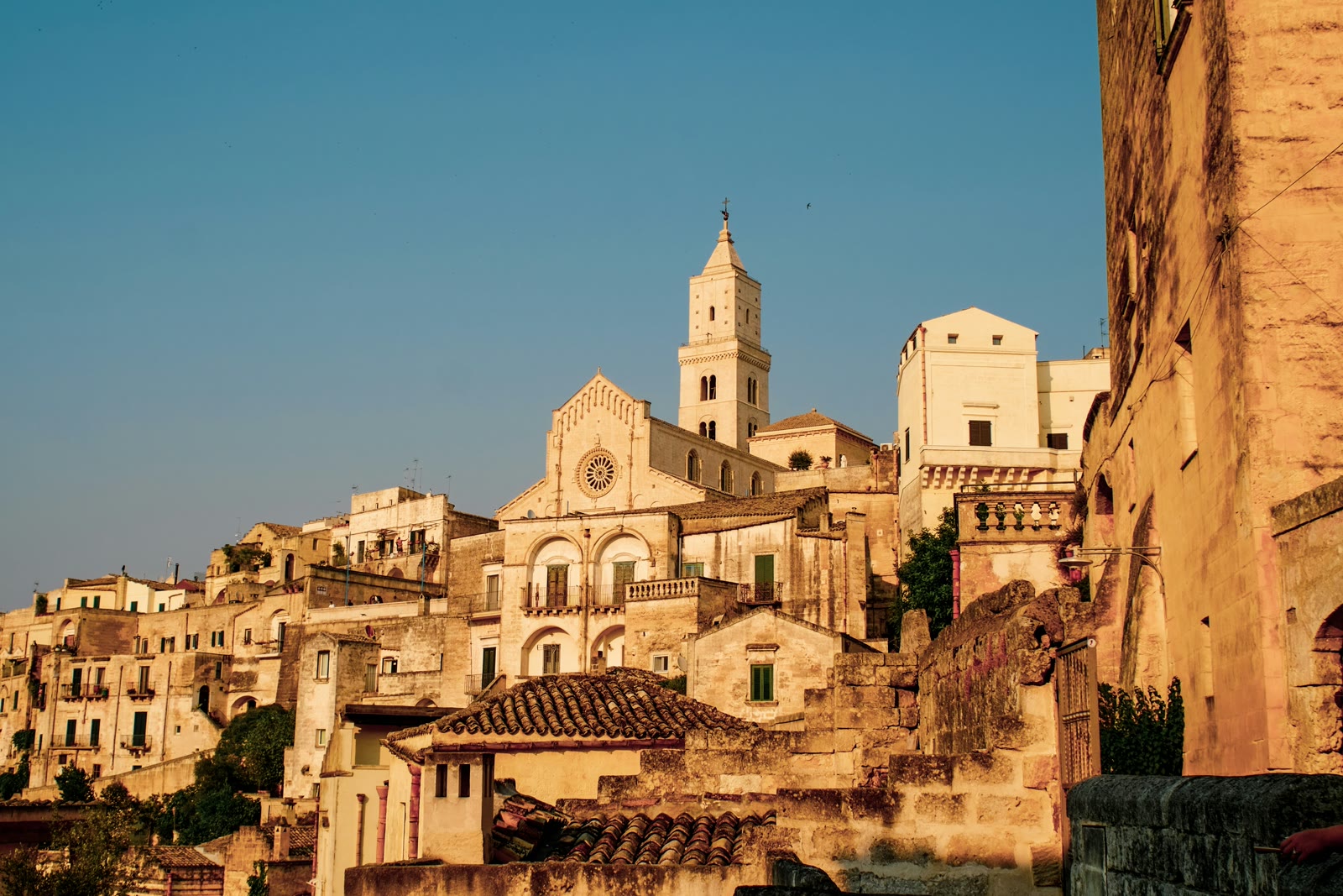 Ancient stone buildings and clock tower of Matera Sassi district, Basilicata, Italy