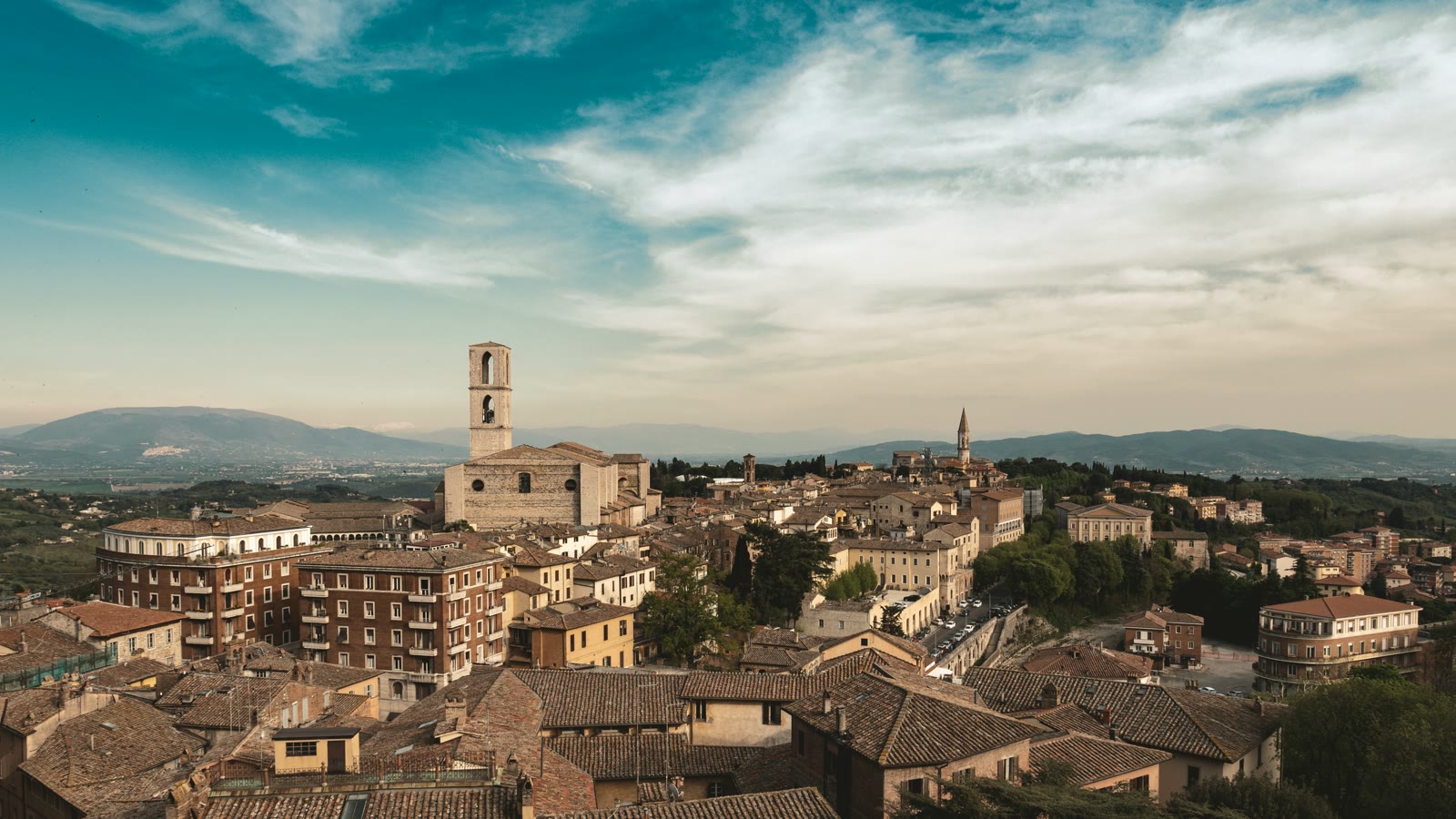 Historic Perugia hilltop with stone buildings under blue sky, Umbria, Italy