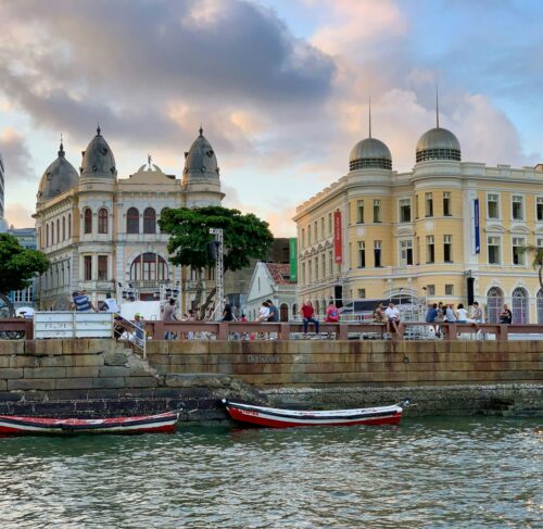 Red and white boat on the water near buildings in Recife, Pernambuco, Brazil