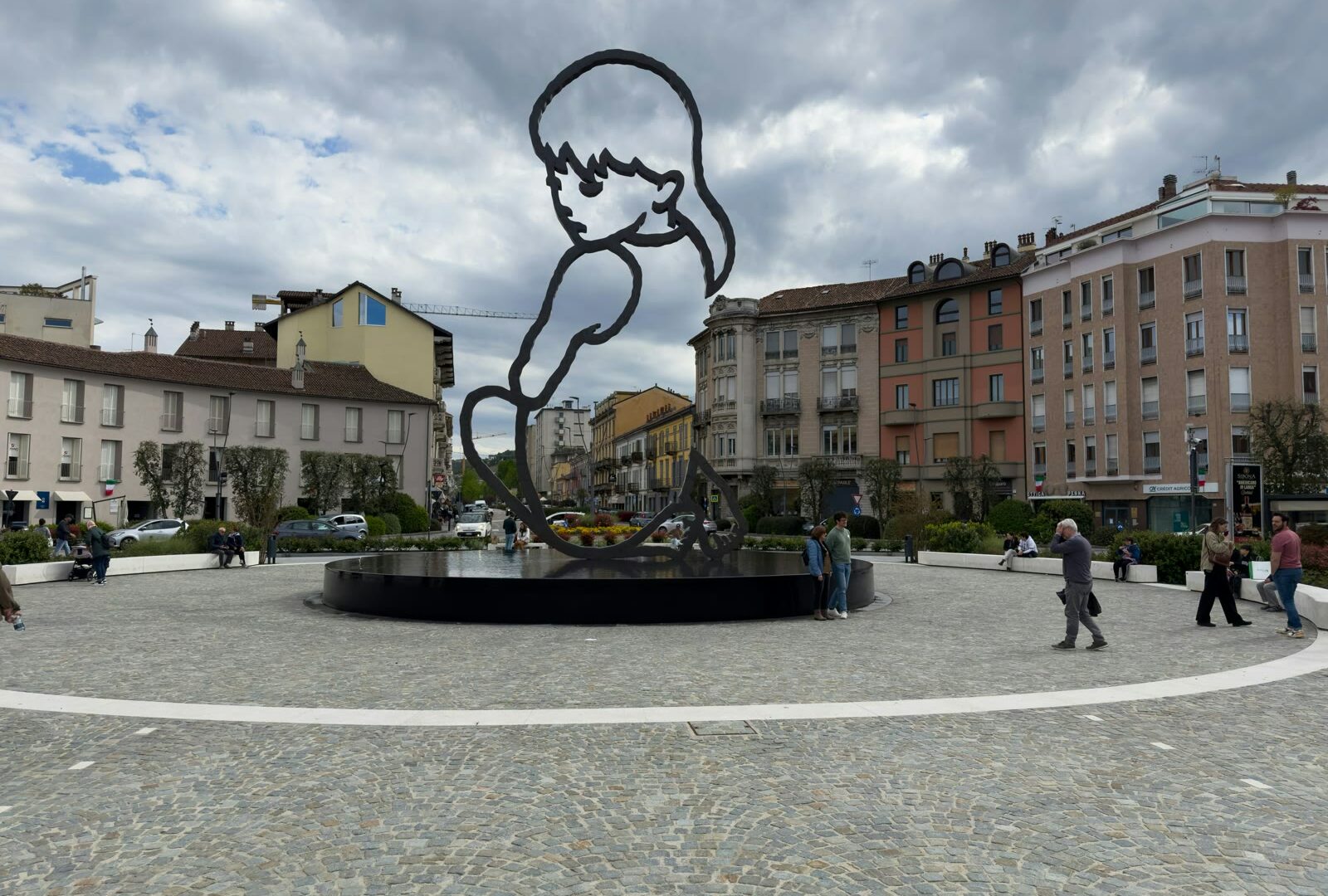 Metal sculpture of a boy in a square in Alba, Piedmont, Italy
