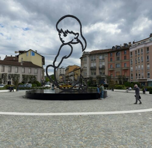Metal sculpture of a boy in a square in Alba, Piedmont, Italy