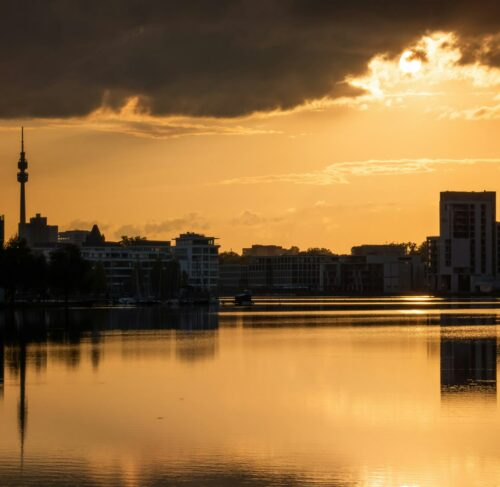 Sun setting over a city and body of water in Dortmund, North Rhine-Westphalia, Germany