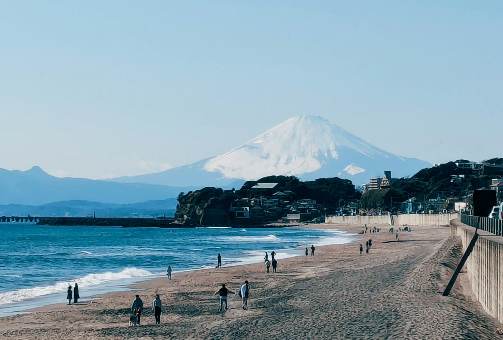 People standing on a sandy beach in Kamakura, Kanagawa, Japan