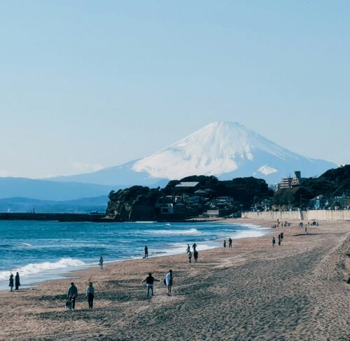 People standing on a sandy beach in Kamakura, Kanagawa, Japan