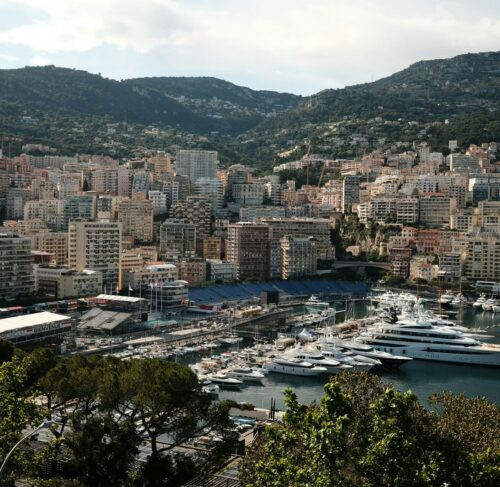 Port with many boats and city in background in Monaco