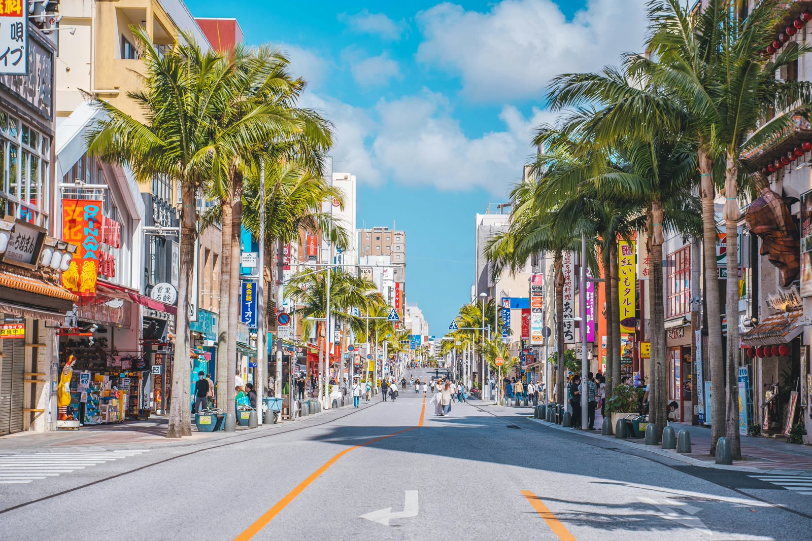 Palm-tree lined street with shops in Naha, Okinawa, Japan