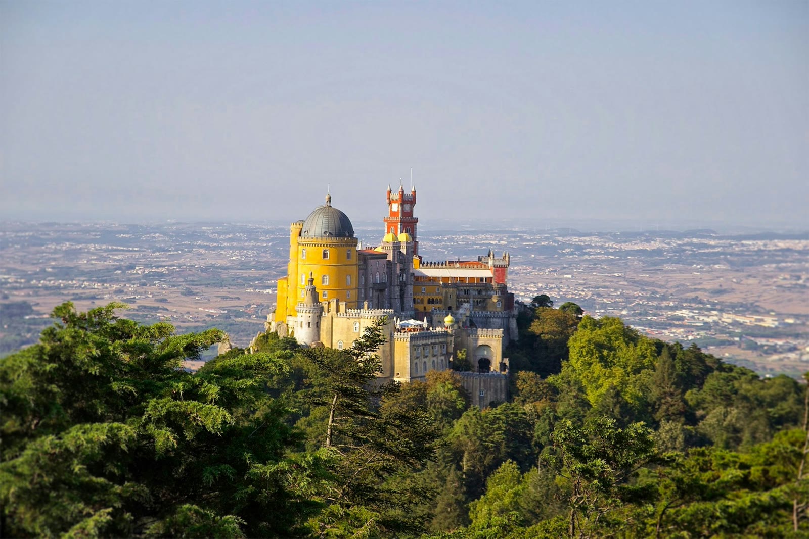 Yellow and grey Pena Palace on a hilltop in Sintra, Lisbon, Portugal