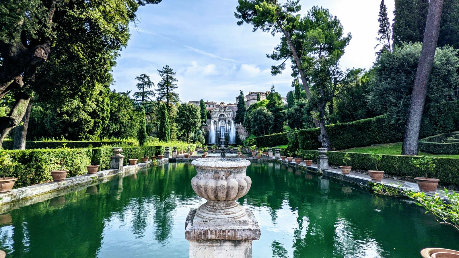 Grand pond surrounded by trees and shrubs at Villa d'Este in Tivoli, Lazio, Italy