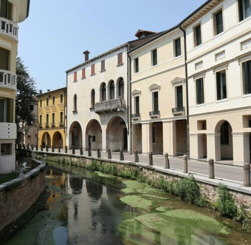 River canal flowing through the city with buildings in Treviso, Veneto, Italy