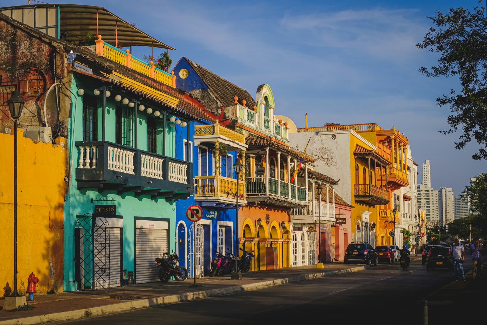 Cars parked in front of a green and white building in Cartagena, Bolivar, Colombia