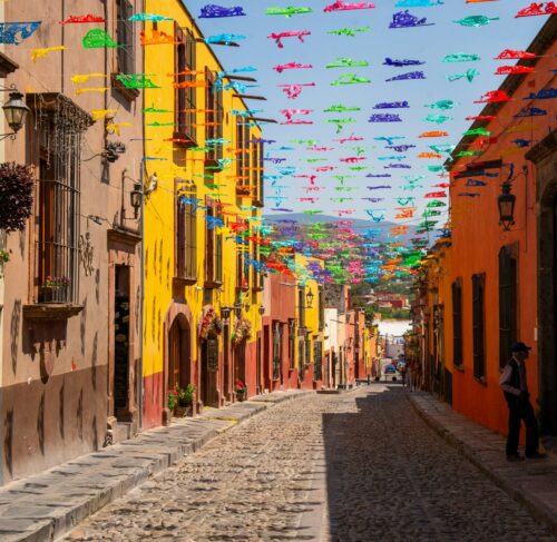 Cobblestone street lined with colorful flags in San Miguel de Allende, Guanajuato, Mexico