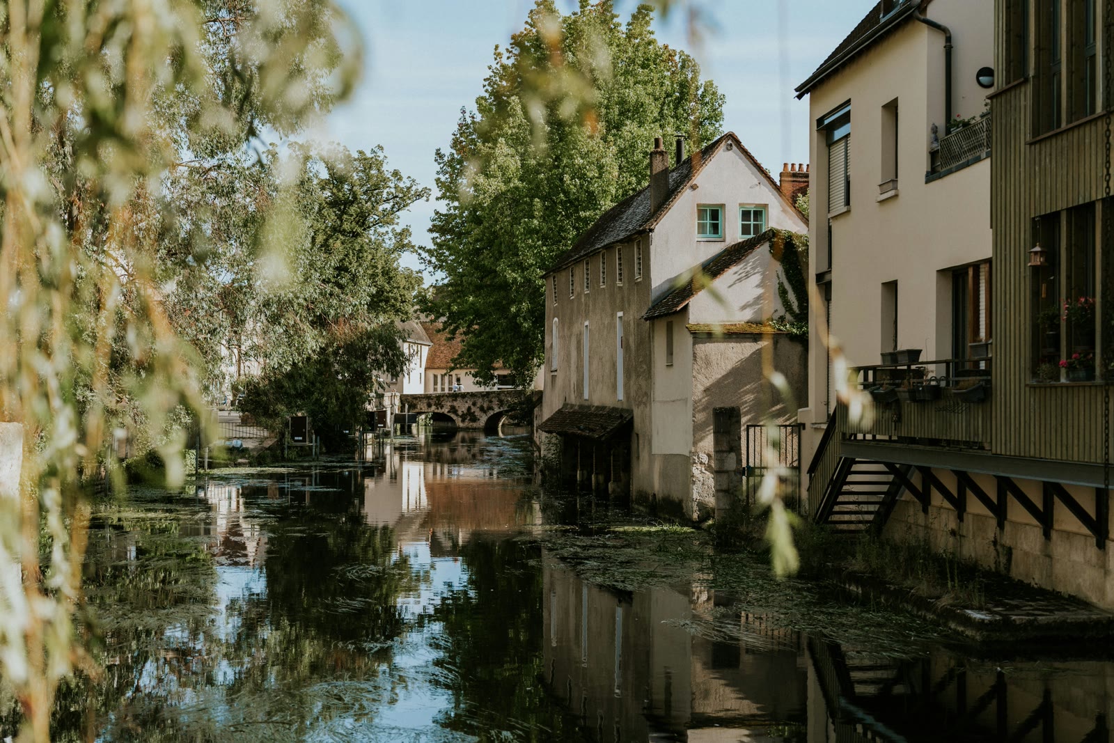River through a city with tall buildings in Chartres, France