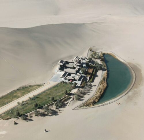 Aerial view of a white and grey house on white sand in Dunhuang, Gansu, China