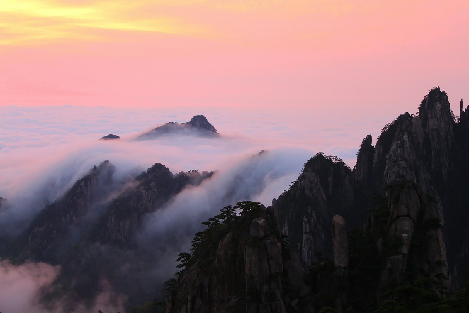 White and black mountains under white clouds in Huangshan, Anhui, China