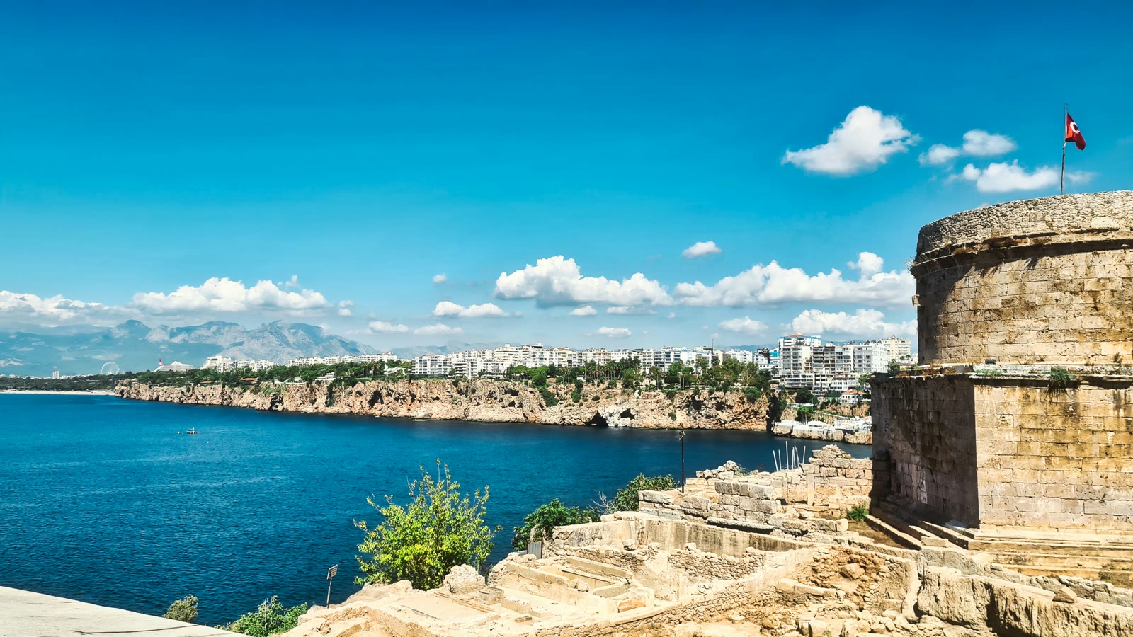 Body of water with a stone wall and flag in Kas, Antalya, Turkey