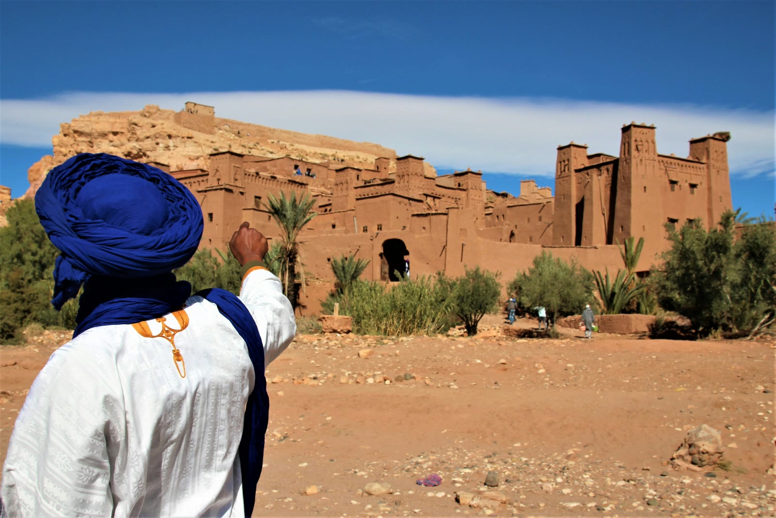Person in a white shirt and blue hat standing on sand in Ouarzazate, Morocco