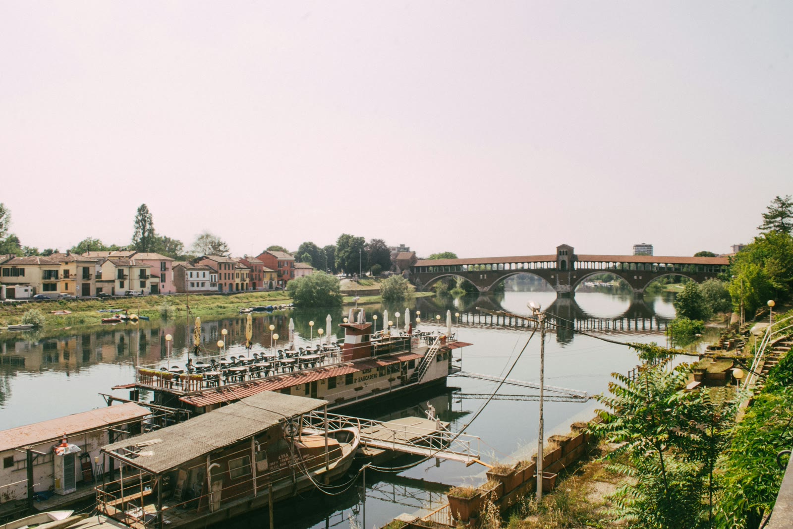 River with a bridge in the background in Pavia, Lombardy, Italy