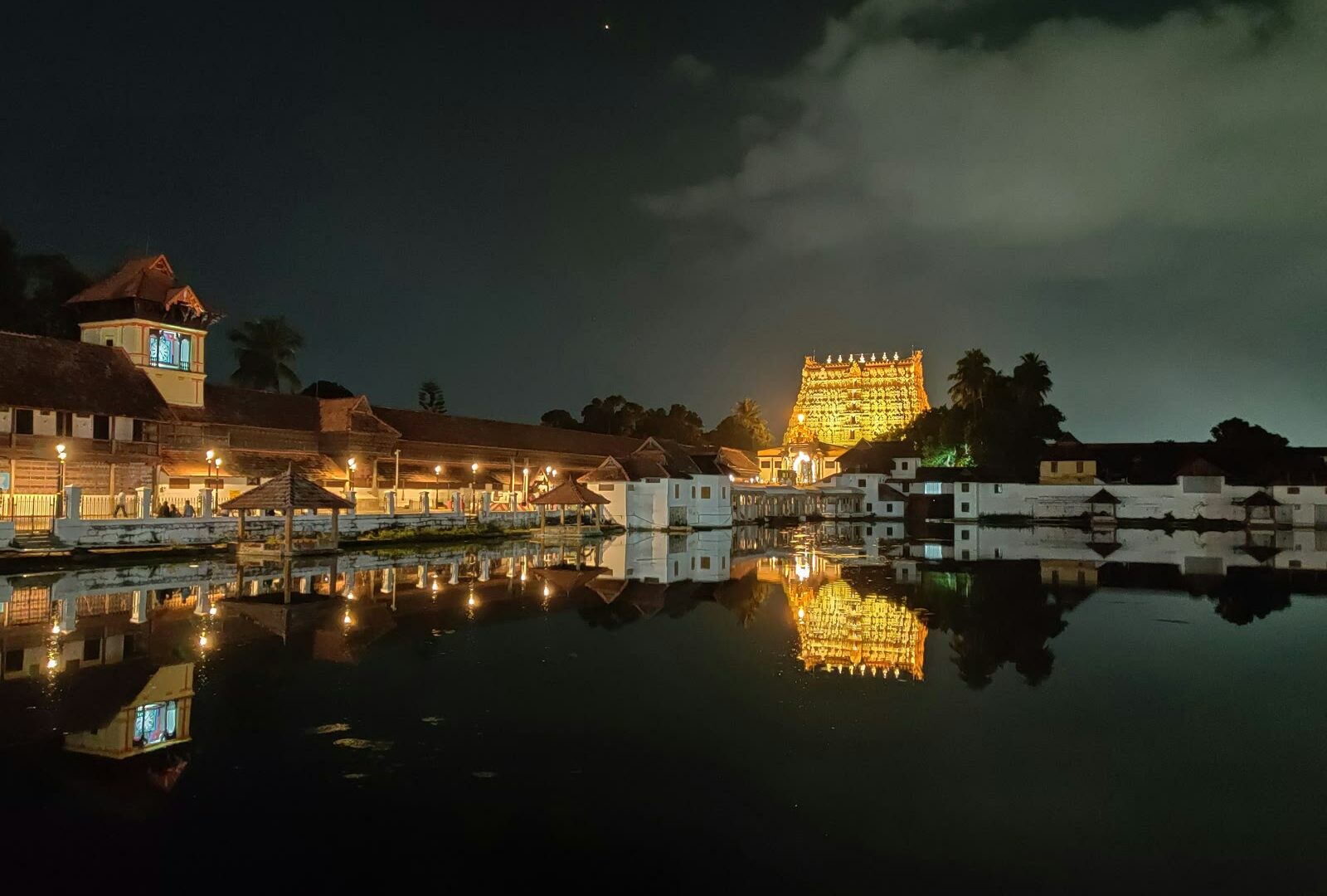 White and brown building near the water at night in Thiruvananthapuram, Kerala, India