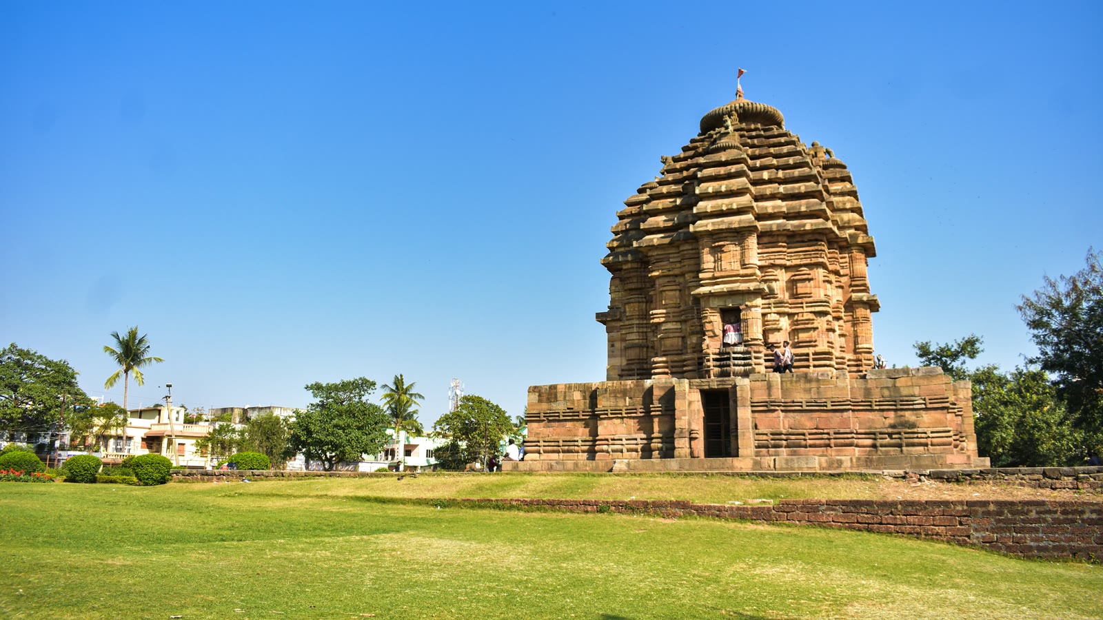 Brown stone temple building under blue sky in Bhubaneswar, Odisha, India