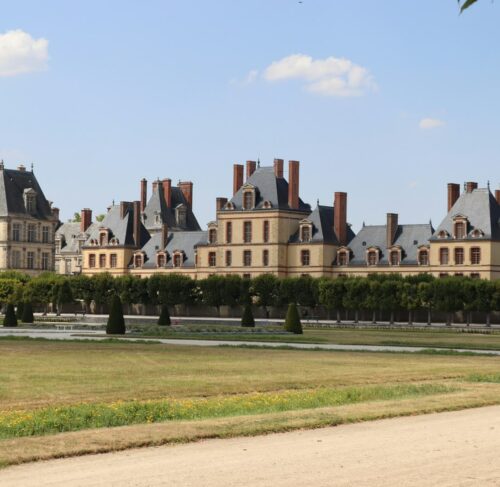Brown stone building under blue sky in Fontainebleau, Île-de-France, France