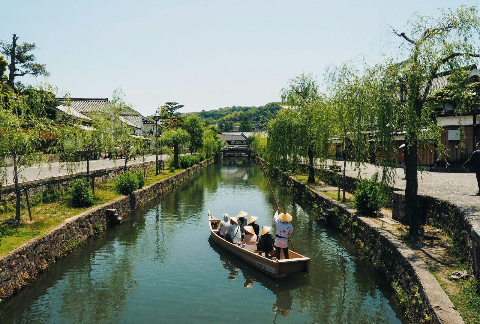 People travelling in boats along the canal in Kurashiki, Okayama, Japan