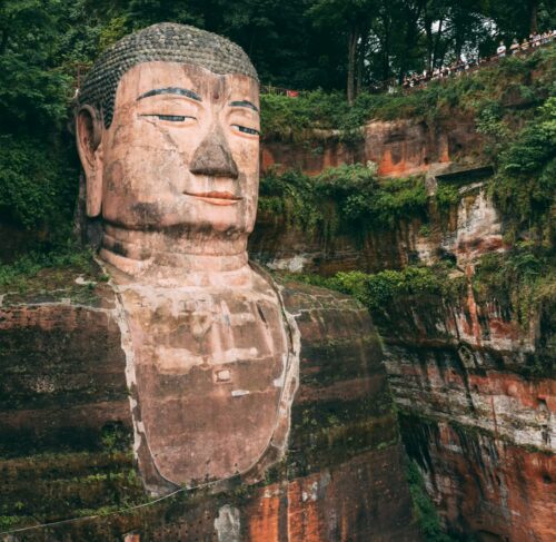 Giant Buddha statue near green trees in Leshan, Sichuan, China