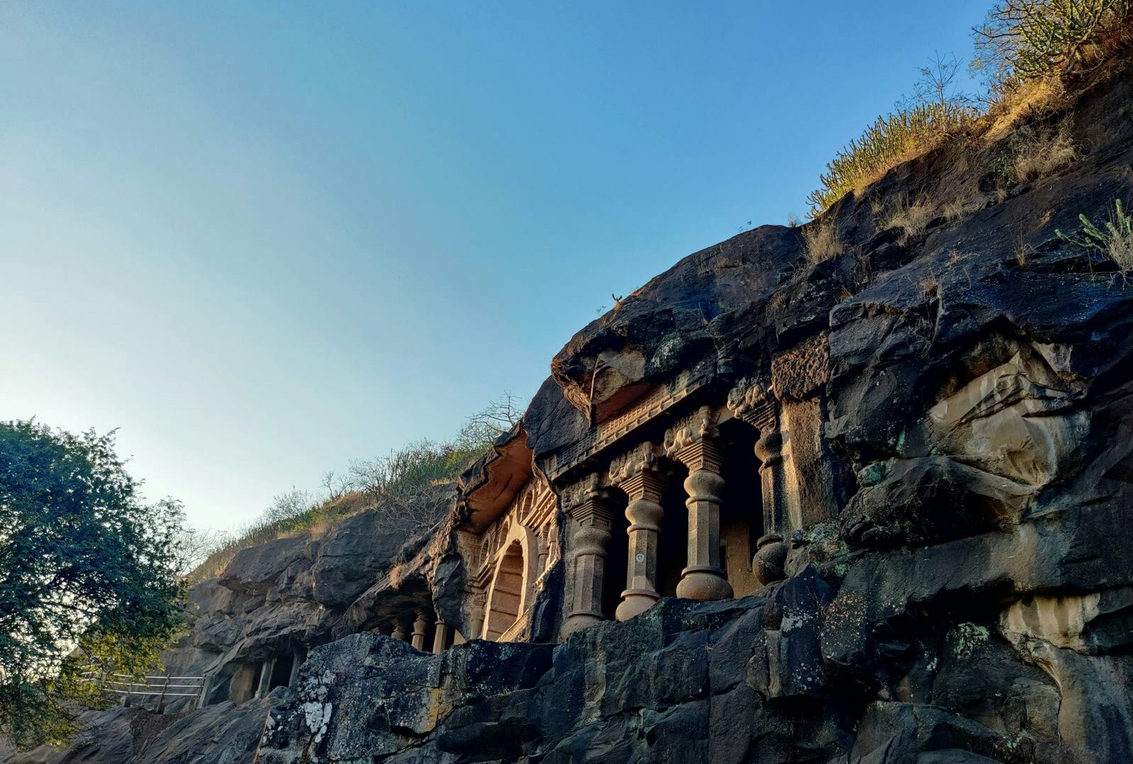 Large rock formation with carved columns in Nashik, Maharashtra, India