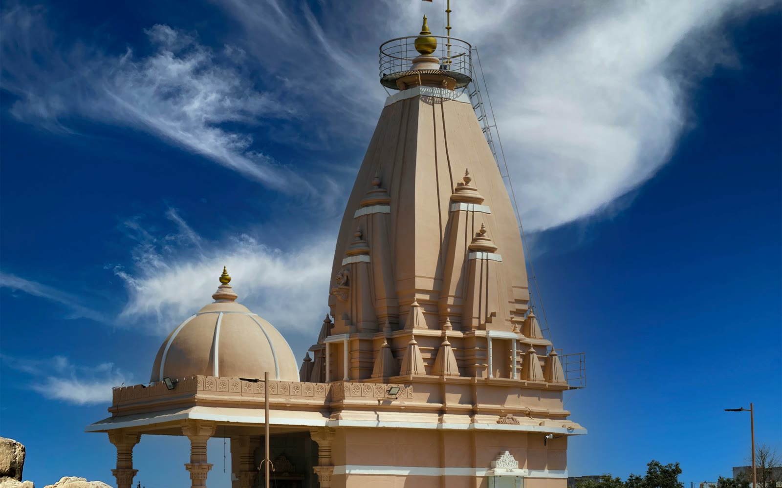Large tan building with a bell tower in Surat, Gujarat, India